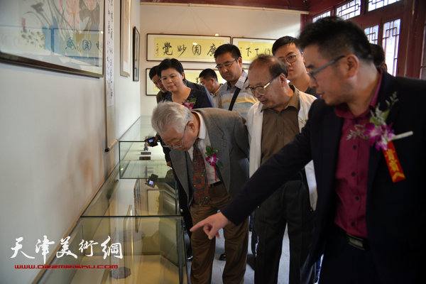 图为方大开陪同来宾观赏方大开艺术馆藏品。